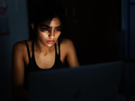A student attempts to do online assignments in the dark.
