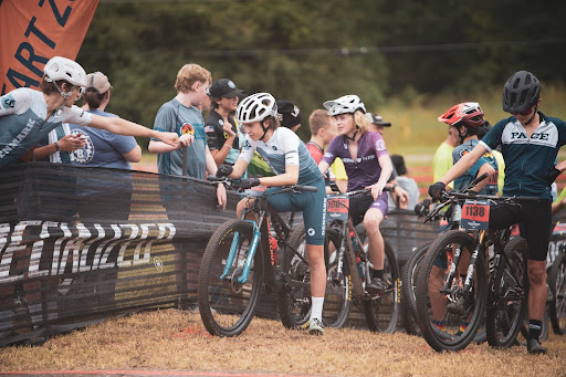 Students congratulate their teammates with fist bumps as they finish their race.