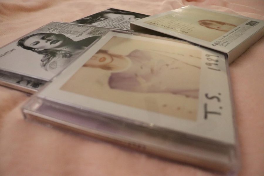 Taylor Swift albums strewn across a bed, brought out in anticipation of Midnights.