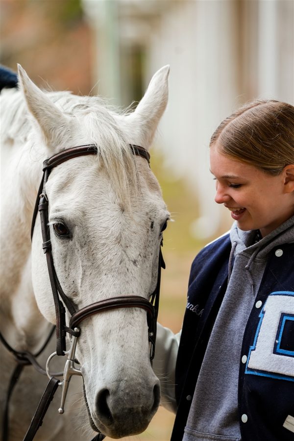 A girl shares a tender, sweet moment with a horse.