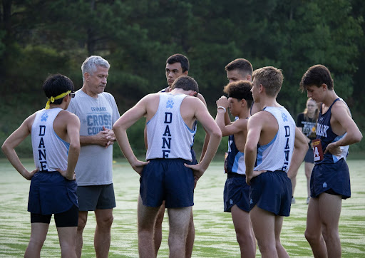 Runners gather around Coach Hudson as he gives words of encouragement