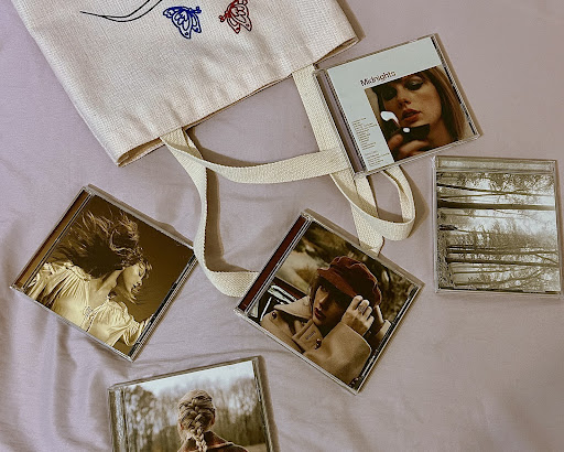 Taylor Swift albums spill out of a bag, showcasing some of her life’s work.