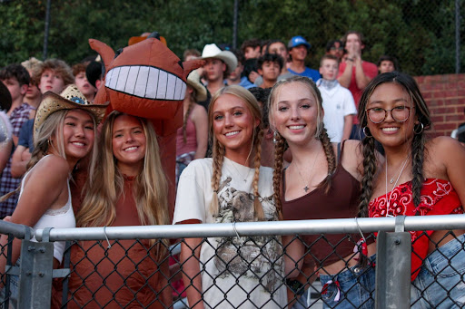 A group of upperclassmen excitingly supporting their classmates at the wild, wild, west game.