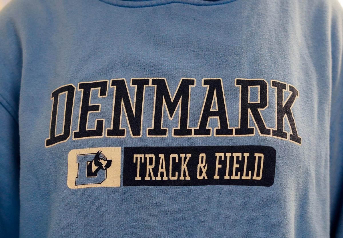 Student representing Denmark Track and field sweatshirt in the hallway.
